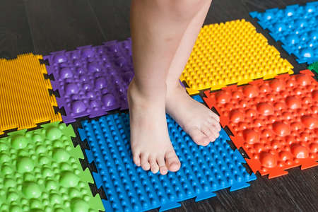 Orthopedic massage mat, selective focus, blurred background. Prevention of flat feet for adults and...