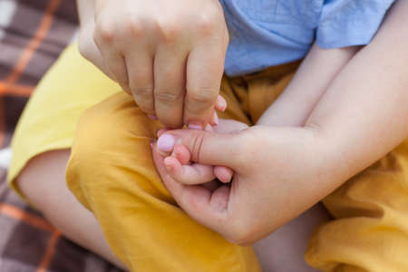 Close-up of a mother doing a hand massage to a disabled boy. disabled children. inclusivity.の写真素材