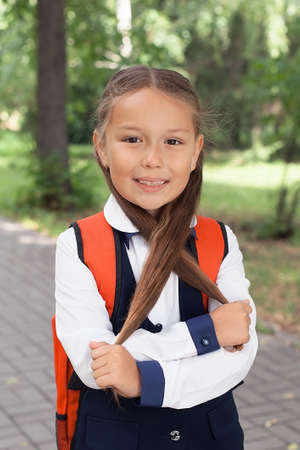 Elegant schoolgirl child girl study with book in park, learning concept.