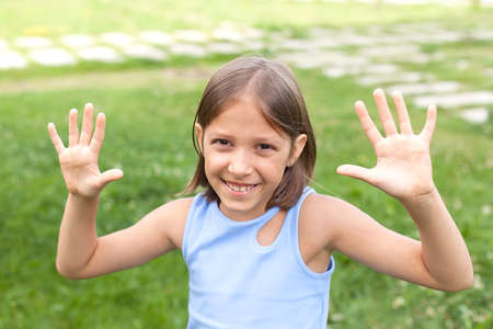 Portrait of a cheerful little girl gesturing and making a funny grimace in front of the camera in a...