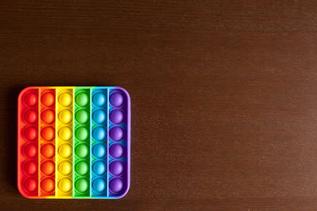 kids anti stress sensory or simple dimple fidget push toy on a black table or floor background....