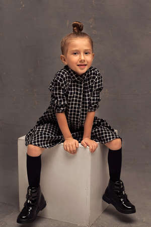 A small smiling girl on a dark background in the studio. children are models. happy childhoodの写真素材