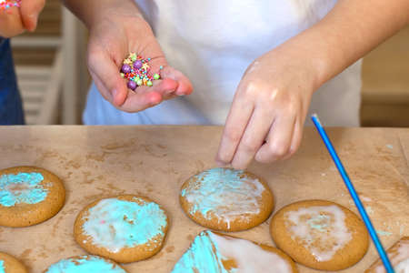 decoration of ginger cookies on a wooden table. sprinkle on cookies. cooking.