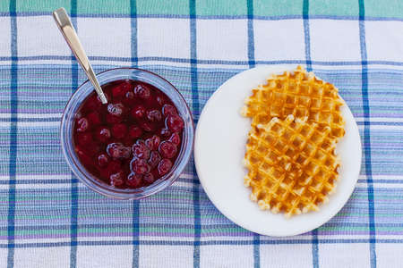 Belgian potato savory waffles with prosciutto, cherry tomatoes, basil leaves and hot tomato jam or spicy sauce. Served breakfast, brunch on light background.の写真素材