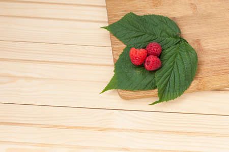 a bowl of fresh ripe and fragrant raspberries in the garden