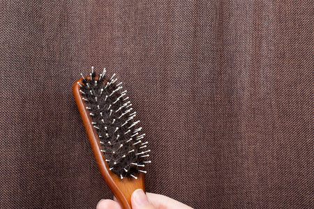 Woman hand holding a comb with hair loss on white background. Health care and medical, Hair loss...