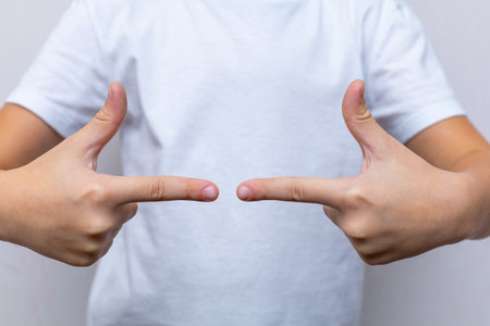 the child folded his arms on his chest in different shapes: a heart, a fistの写真素材