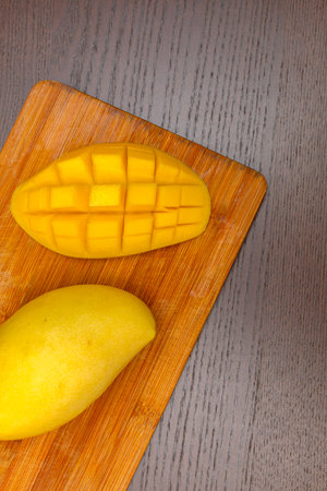 Mango fruit and mango cubes on the wooden table