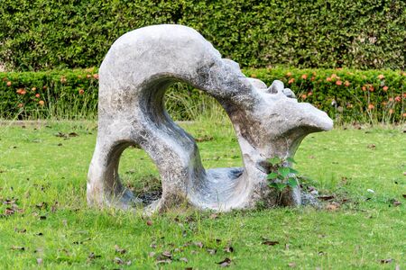 Art of big granite ,marble rock stone with holes in the garden zen japan style .Decorative Sculpture rock aged stone on grass at home.Texture and background decorate outdoor object art at home conceptの写真素材