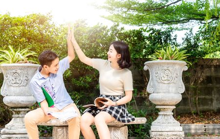 Adorable happy brother sister take care sitting on bench in  garden together.Activity outdoors on summer dayの写真素材