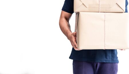 Cheerful young delivery man holding stacking cardboard boxes,parcel, while standing isolated on...