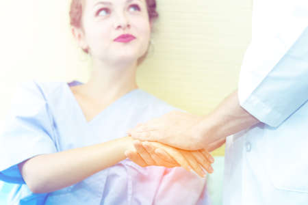 Closed up of Hands of doctor man reassuring woman patient on bed in  hospital .Professional medical doctor comforting patient at consulting room. Medical ethics and trust healthcare conceptの写真素材
