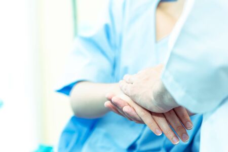 Closed up of Hands of doctor man reassuring woman patient on bed in  hospital .Professional medical doctor comforting patient at consulting room. Medical ethics and trust healthcare conceptの写真素材