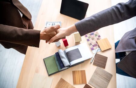 Meeting of Insurance agent and customer shaking hand after signing contract for realty purchase in...