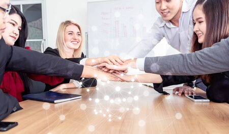 Multiracial business people collapse stacking hands over work table in modern meeting room.Teamwork...