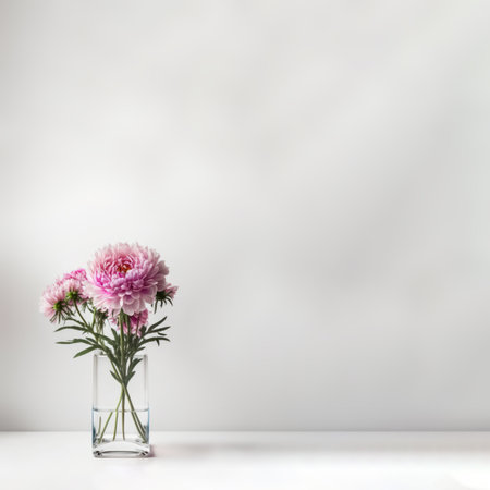 Pink blossom flower in glass vase on table with white background. Copy space.の写真素材