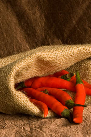 Bag of small hot red pepper on a brown background