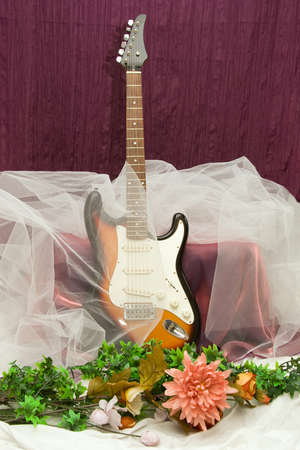 Composition with guitar and different artificial flowersの写真素材