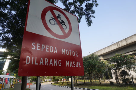Motorcycle prohibited traffic road sign No motorbike or no parking panel red white at airportの写真素材