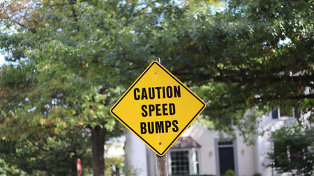 Caution speed bumps signpost on the street