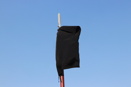 The black flag flying in the wind.の写真素材