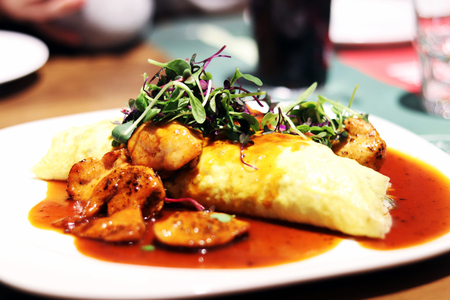 A plate of fried rice wrapped in a thin omelette
