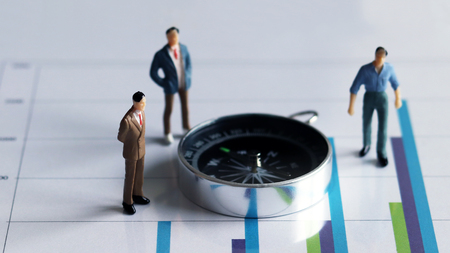 Compass and three miniature men on the chartの写真素材