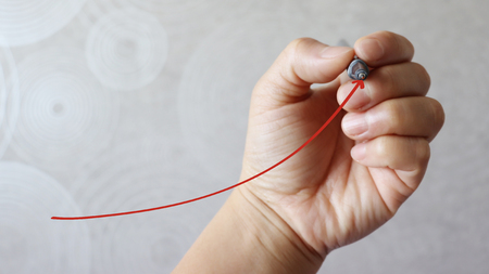 A pen hand drawing a red arrow.
