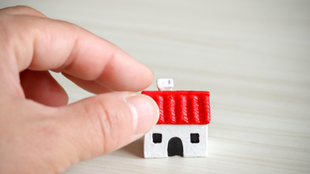 Dream to become a homeowner. The finger holding the miniature houseの写真素材