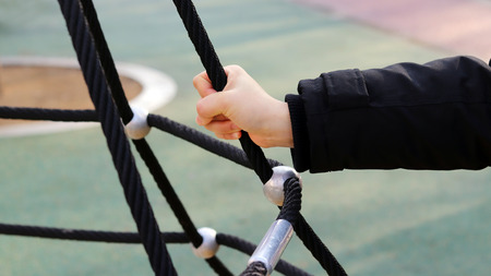 A hand holding a black ropeの写真素材