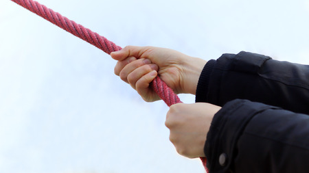 A hand holding a red ropeの写真素材