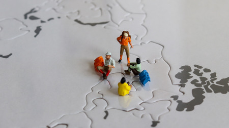 Miniature tourists on world map puzzle.の写真素材