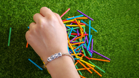 A bracelet hand of LOVE cube and multicolor stick.
