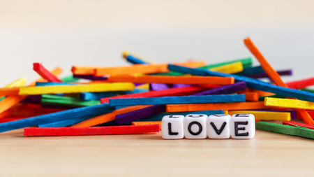 A stacked wooden rainbow stick and LOVE text cube.の写真素材