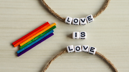 Thread an alphabet through a rope. Rainbow stick. LOVE IS LOVE.の写真素材