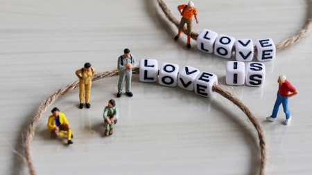 LOVE IS LOVE. Thread an alphabet through a rope. Miniature people shot imageの写真素材