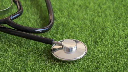 Close-up image of a stethoscope over a green grass.の写真素材