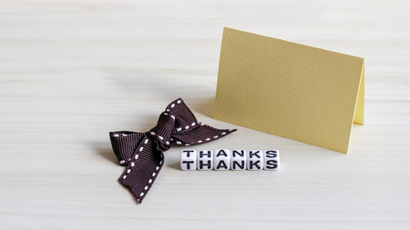 Alphabet cube of THANKS text on the wood background. Thank you card and brown ribbon.の写真素材