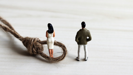 A miniature of a woman trapped in a rope and a miniature man.の写真素材