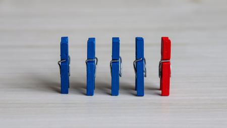 Four blue tongs standing side by side and a red tongs.の写真素材