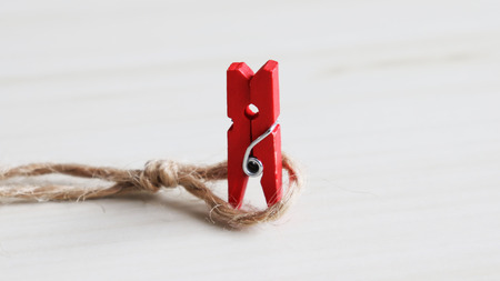 A red wooden peg is trapped in a rope. The concept of discrimination against women's advancement into society.の写真素材
