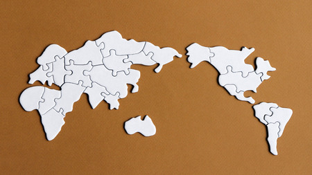 A world map puzzle with a brown backgroundの写真素材