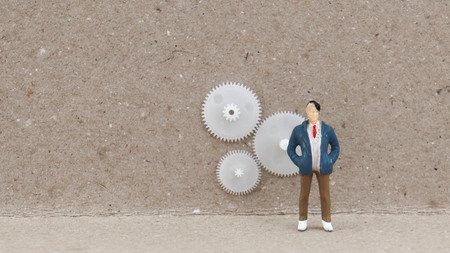 A miniature man standing in front of three springs.