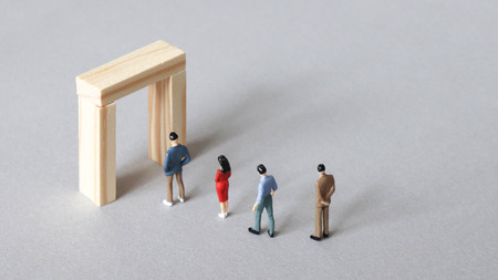 Miniature people lined up to the narrow doors.