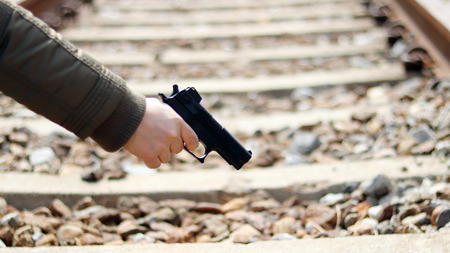 A hand of woman with a gun.