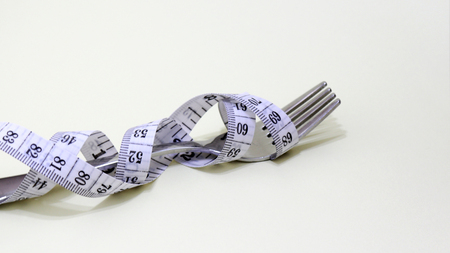 A fork wrapped in a tape measure.の写真素材