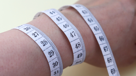 Close-up image of a tape measure around one's wrist.の写真素材