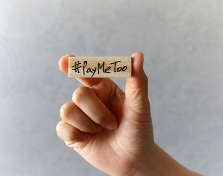 #PayMeToo as a new movement concept. Hand holding a wooden block with #PayMeTooの写真素材