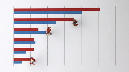 The concept of a growing income gap. Miniature people standing on a bar graph.の写真素材