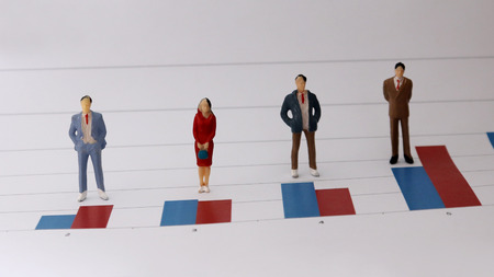 Miniature people standing on a bar graph. The concept of people at work is judged by numerical values.の写真素材